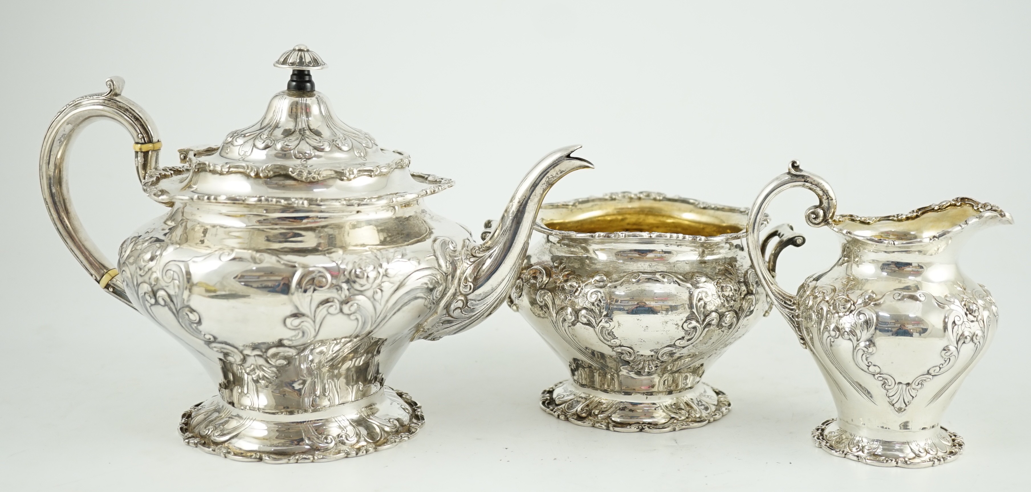 An Edwardian Scottish repousse silver three piece tea set, by Robert Scott